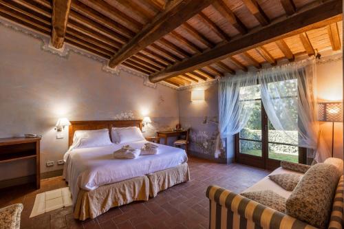 a bedroom with a bed and a couch and a window at La Melosa Resort & Spa in Roccastrada