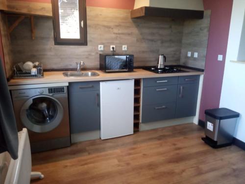 une cuisine avec un évier et une machine à laver dans l'établissement La Mésange Charbonnière, à Lucéram