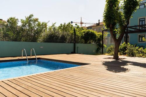 a swimming pool on a wooden deck next to a house at Casa Nina in Porto