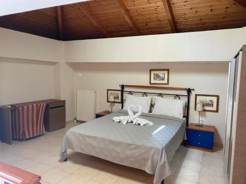 a bedroom with a bed with two white towels on it at Villa Avra in Poros