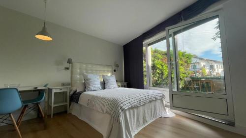 a bedroom with a bed and a desk and a window at Apartamentos El Caserio in Suances