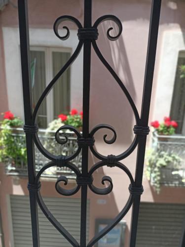 a black iron gate with red flowers in a window at Romantico Rifugio in Guardiagrele