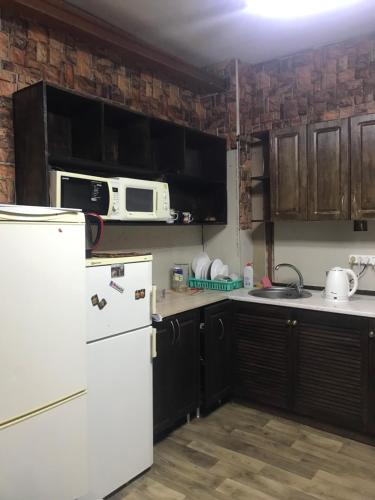 a kitchen with a white refrigerator and a microwave at Kosher Hostel in Odesa