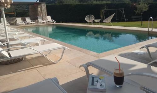 a drink sitting on a table next to a swimming pool at Alex House in Zacharo