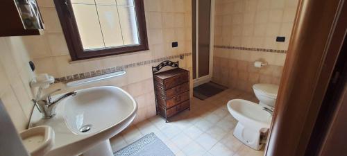 bagno con 2 lavandini, servizi igienici e specchio di Appartamento in Centro a Lampedusa