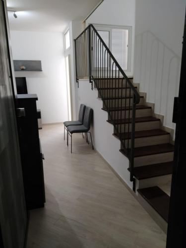 un escalier avec une chaise et un escalier dans l'établissement la casa di sara, à Quartu SantʼElena