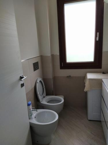 La salle de bains est pourvue de toilettes, d'un lavabo et d'une fenêtre. dans l'établissement la casa di sara, à Quartu SantʼElena