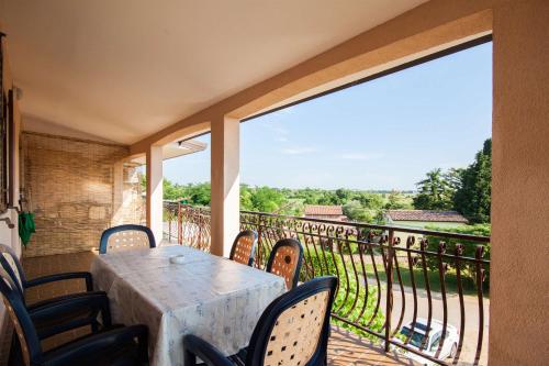 a table and chairs on a balcony with a view at Apartments Dara in Umag