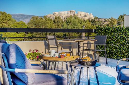 a balcony with tables and chairs with a view ofhens at Acropolis Vision in Athens
