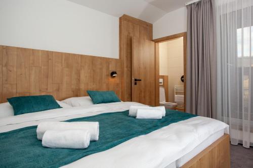 duże łóżko z dwoma poduszkami na górze w obiekcie Apartmány Bachledka w Zdziarze
