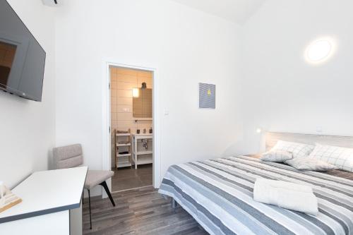 a bedroom with a bed and a desk and a television at VILLA SANDRINA in Vrh