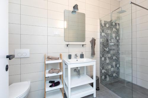 a white bathroom with a sink and a shower at VILLA SANDRINA in Vrh