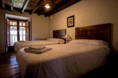 オヨス・デル・エスピーノにあるLa Casa del Abueloのベッドルーム1室(ベッド2台、タオル付)