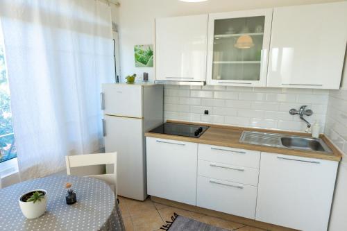 a kitchen with a white refrigerator and a table at Apartments Biserka in Božava