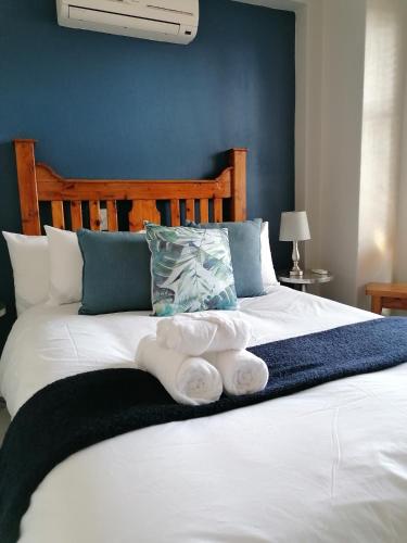 a bed with two towels on top of it at De Akker Guest House in Bloemfontein