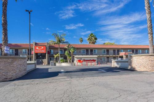 a hotel with palm trees in front of a building at Econo Lodge Inn & Suites Escondido Downtown in Escondido