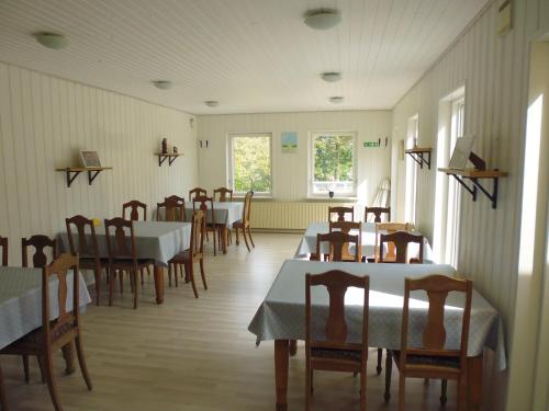 a restaurant with tables and chairs in a room at Otel Vaabensted in Sakskøbing
