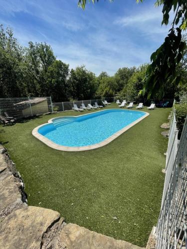 a large swimming pool with lounge chairs and a yard at Gîtes des Campanes in Saint Alban Auriolles