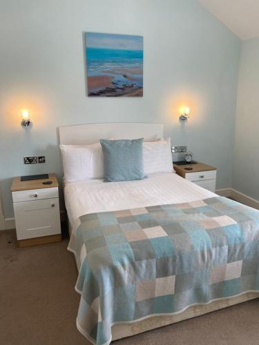 1 dormitorio con 1 cama grande y 2 mesitas de noche en Oceandrive en Barmouth