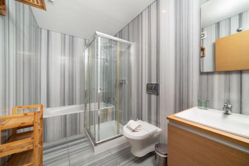 uma casa de banho com um chuveiro, um WC e um lavatório. em Baia Residence 2 - Holiday Apartments - By SCH em São Martinho do Porto