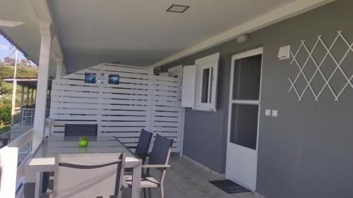 a patio with a table and chairs on a balcony at Garlis Apartments in Psakoudia