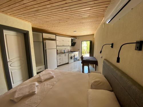 a bedroom with a large bed and a kitchen at Beyoglu Pansiyon in Patara