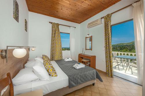 a bedroom with a bed and a balcony with a table at Villa Kapnisi in Vasilikos