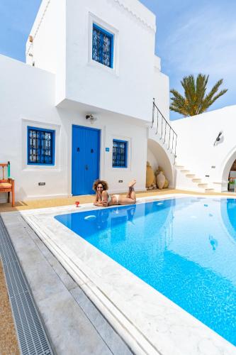 a villa with a swimming pool in front of a house at Villa Jasmin in Houmt Souk