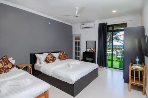 1 dormitorio con 2 camas y ventana en Paradise Retreat, Maafushi en Maafushi