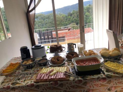 a table with food on it with a view at hospedagens regina in Águas de Lindóia