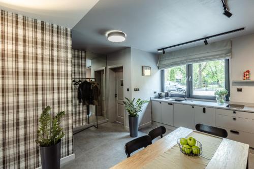 a kitchen and dining room with a table and chairs at Apartamenty Caminski Deluxe in Kudowa-Zdrój