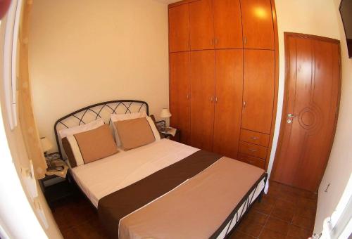 哈拉奇的住宿－Aegean Seaview，一间卧室配有一张床和一个木制橱柜