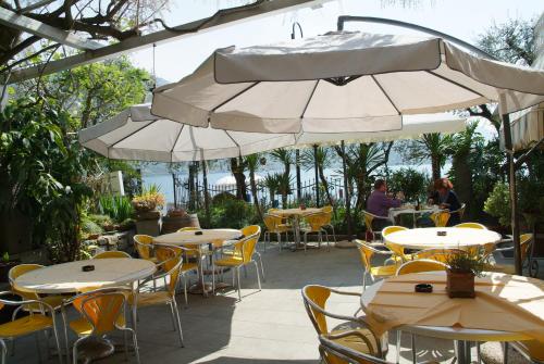 a patio area with tables, chairs, umbrellas and umbrellas at La Foresta Monteisola in Monte Isola