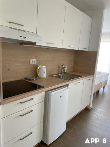a kitchen with white cabinets and a sink at Casa Maly in Portorož