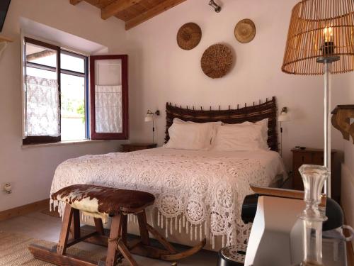 1 dormitorio con cama, mesa y ventana en Ponte Pedra - Melides Country House Adults Only, en Melides