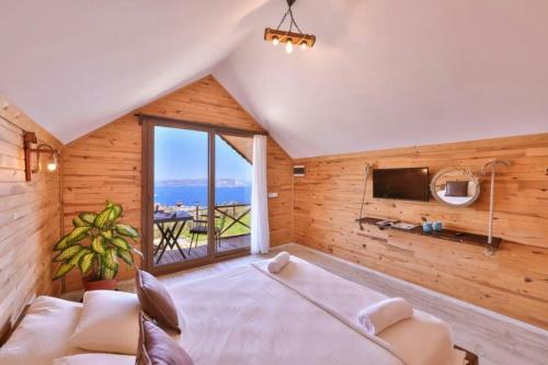 a bedroom with a large bed and a tv at Ali's Bungalow in Kaş