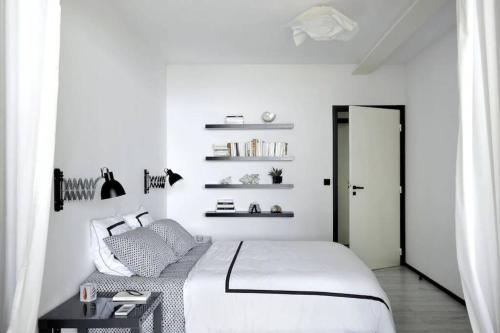 une chambre blanche avec un lit et une table dans l'établissement Villa Niel - accès direct mer et piscine chauffée, à Hyères