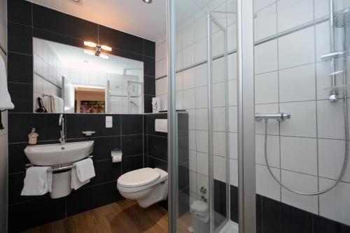 a bathroom with a toilet and a sink and a shower at Hotel Alt Speyer in Speyer