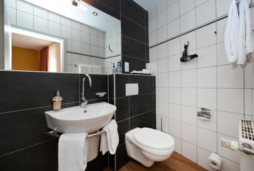 a bathroom with a white toilet and a sink at Hotel Alt Speyer in Speyer