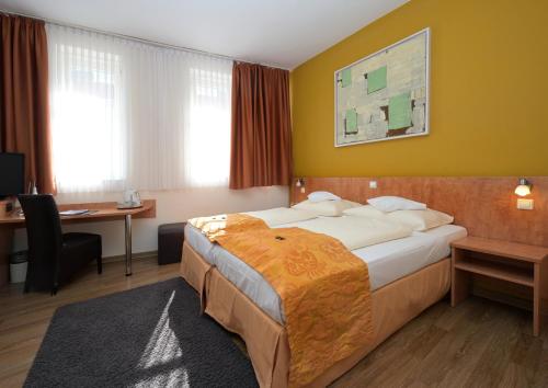 a hotel room with a bed and a desk at Hotel Alt Speyer in Speyer