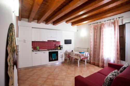 eine Küche und ein Wohnzimmer mit einem Tisch in der Unterkunft The House of Castle Apartments in Castelbuono