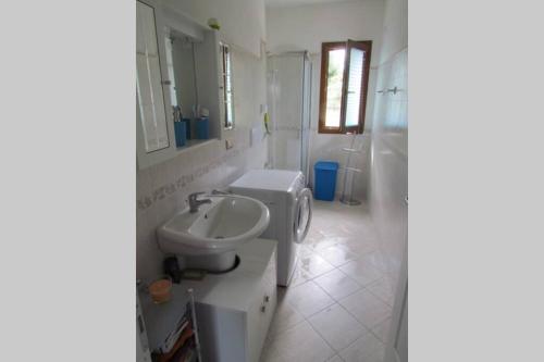 La salle de bains blanche est pourvue d'un lavabo et de toilettes. dans l'établissement Apartment - La dolce vita - where dreams come true, à Valledoria