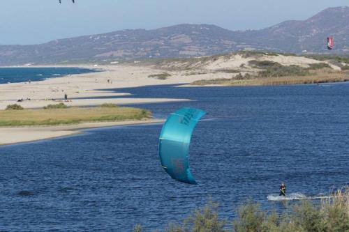 a person kite surfing in the water near a beach at Apartment - La dolce vita - where dreams come true in Valledoria