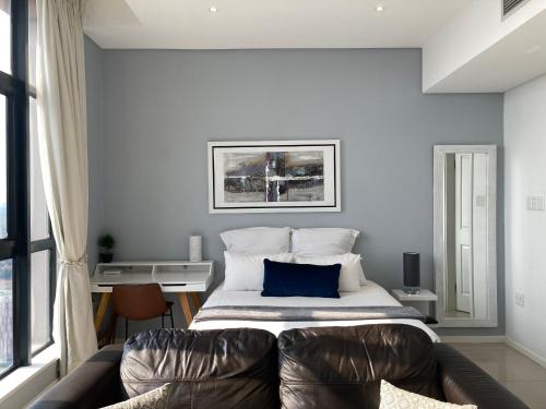 a bedroom with a bed with a blue pillow at Urban Awe Apartment-iTowers 23rd Floor in Gaborone