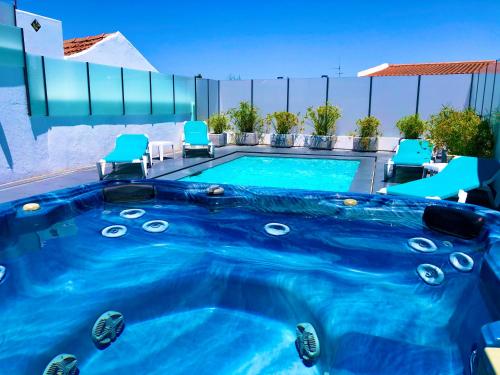 a swimming pool with a blue pool at Luxury Villa with Private Pool e Jacuzzi Year-Round a 25 min de Lisboa in Setúbal