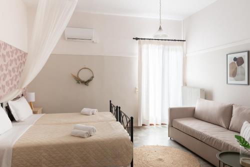 a white bedroom with two beds and a couch at Germany in Olympiada