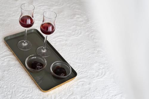 a tray with two glasses of red wine on a bed at Germany in Olympiada