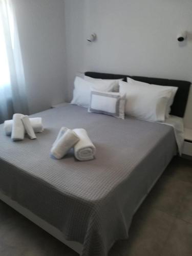 a large bed with two towels and pillows on it at Aiolos Blu Luxury Apartments in Nea Roda
