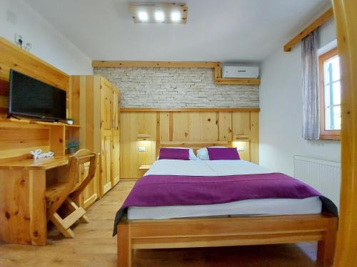 a bedroom with a large bed and a television at Plitvice Ethno House in Jezerce