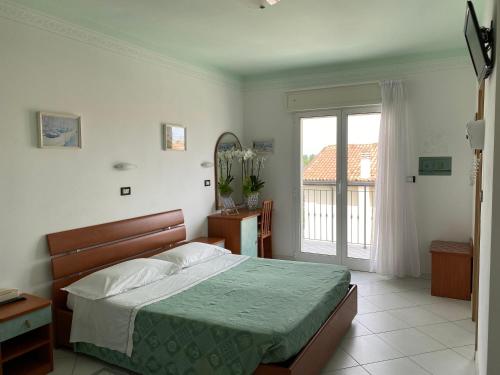 a bedroom with a bed and a large window at Hotel Capri in Bellaria-Igea Marina